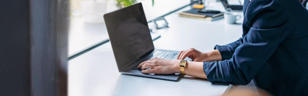 Νεαρή γυναίκα εργάζεται σε φορητό υπολογιστή σε ένα σύγχρονο γραφείο.