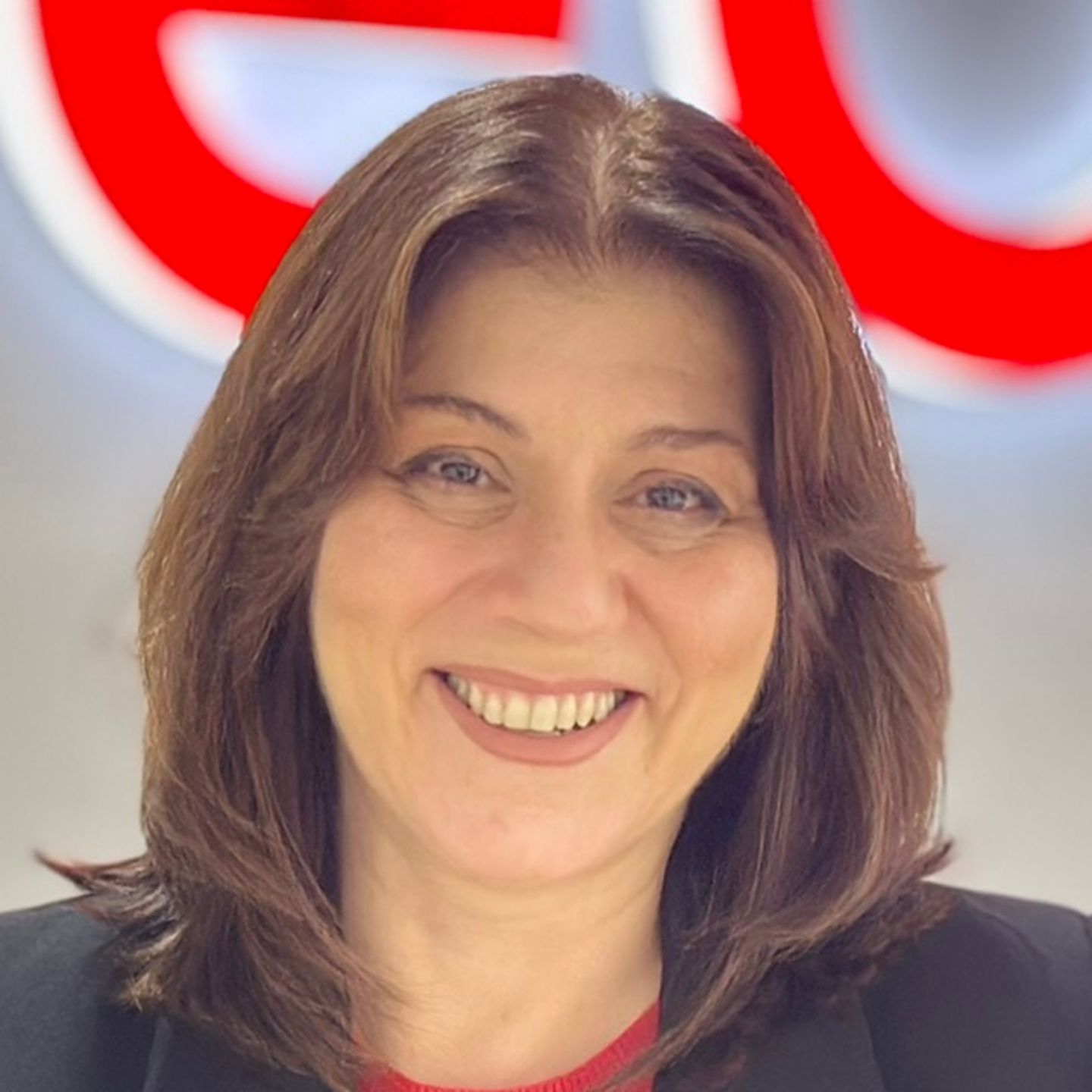 Ο Belén Barreiro, εκπρόσωπος του Κέντρου Επικοινωνίας στην EOS στην Ισπανία, ακουμπάει σε έναν πάγκο με μαύρο σακάκι μπροστά από ένα φωτεινό λογότυπο της EOS.